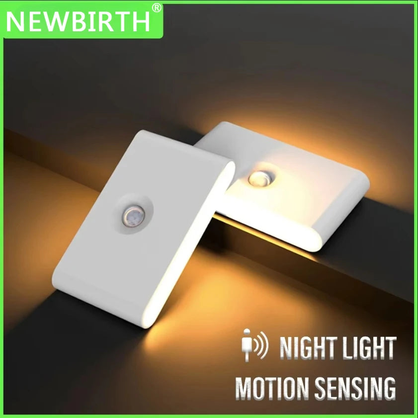 Two white, rectangular mini motion sensor night lights, one glowing warmly, on a dark surface.